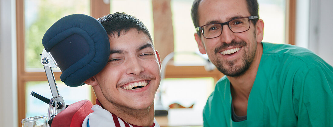 Picture: An educator and his pupil, both laughing and looking into the camera.