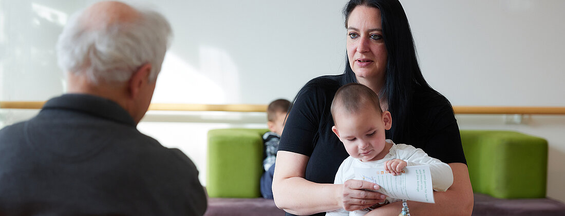 Bild: Eine Mutter mit Ihrem kleinen Kind wird von einem Sozialarbeiter der Kinderklinik beraten