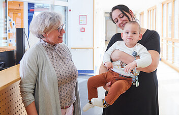 Bild: Eine Mutter und Ihr Kind werden am Empfang der Kinderklinik begrüßt