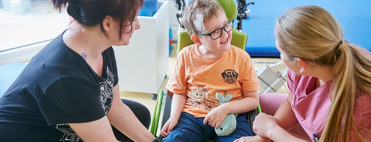  Picture: A therapist advises a mother and her child on the subject of aids and mobilisation.