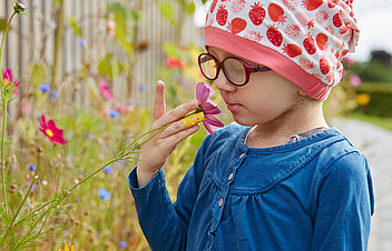 Photo: A small patient smells a flower in the garden area of the children's clinic in Schömberg.