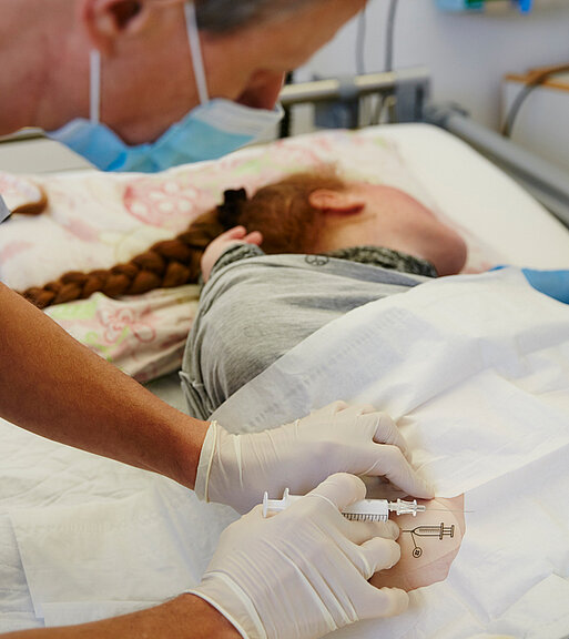 Bild: Ein Arzt befüllt die Baclofenpumpe einer Patientin