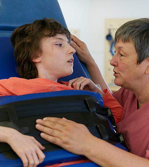 Picture: A therapist cares for a patient in a standing frame.