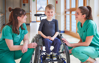 Picture: Two therapists take care of a boy in a wheelchair