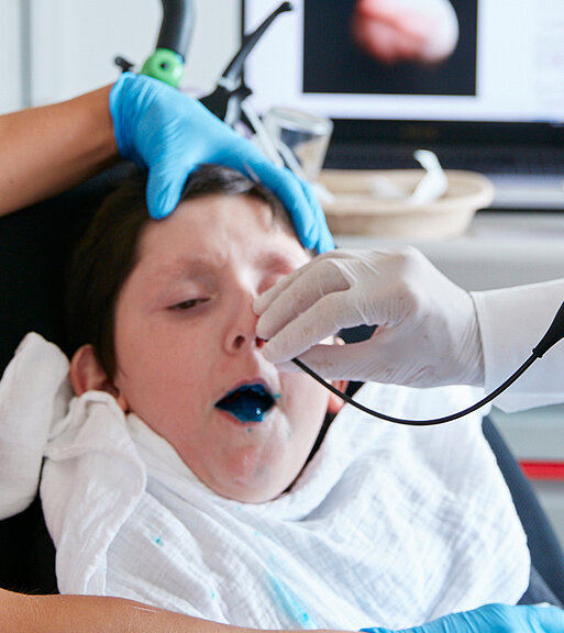Bild: Ein Arzt führt im Rahmen des Trachealkanülenmanagements mit einem Endoskop über die Nase des Patienten eine Untersuchung der Schluckfunktion durch