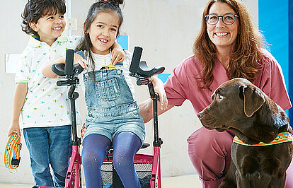 Picture: 2 little patients of the paediatric clinic with the therapy dog Fanny and the therapist