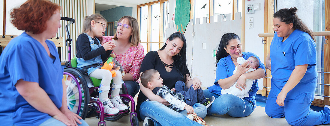 Bild: Eltern und Pflegekräfte der Kinderklinik betreuen gemeinsam Kinder unterschiedlichen Alters