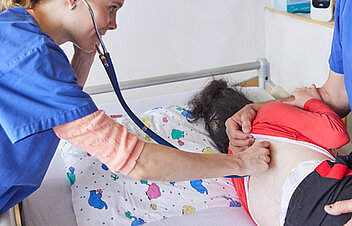 Bild: Ärztin untersucht mit einem Stethoskop die Atmung einer Patientin