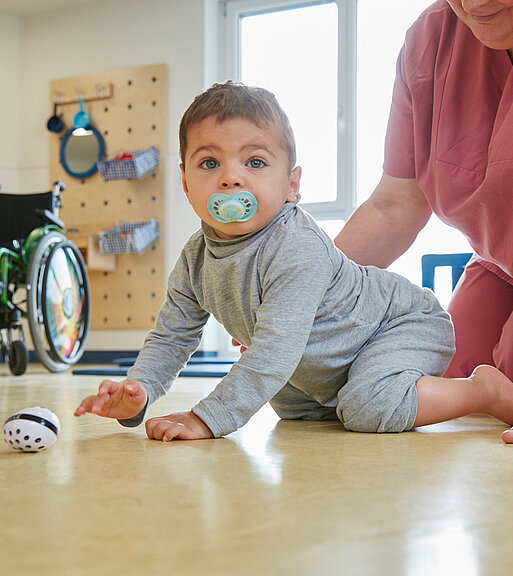 Bild: Die Physiotherapeutin überprüft den motorischen Entwicklungsstand eines Kleinkindes