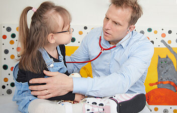 Picture: A doctor at the paediatric clinic checks the breathing of a small patient with his stethoscope.