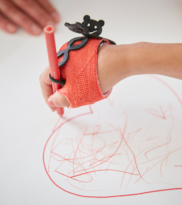 Functional orthoses enable better use of the hand Picture: With the help of a functional orthosis on the hand, the patient can hold a pencil and also draw