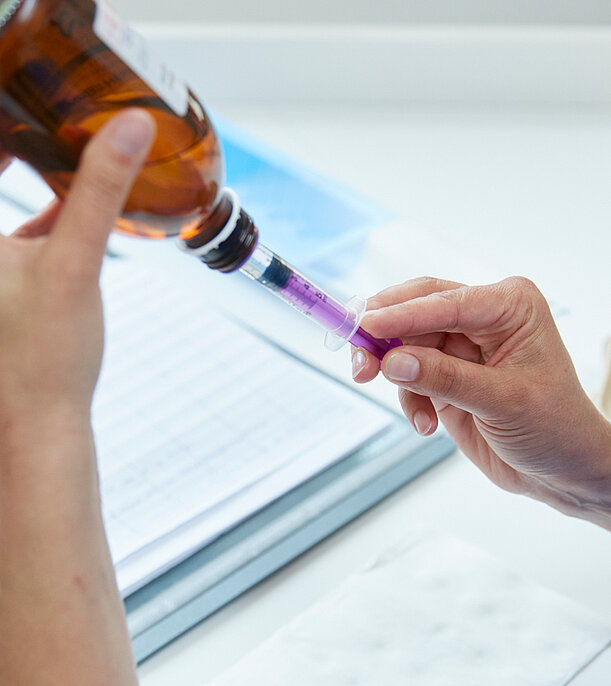 Picture: A nursing staff member prepares a syringe with a drug in juice form