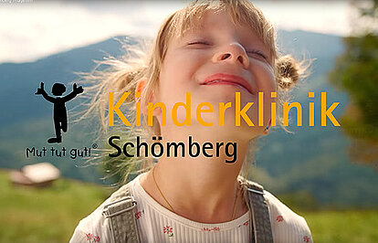 Ein kleines Mädchen steht vor eine grünen Landschaft und genießt den lauen Wind