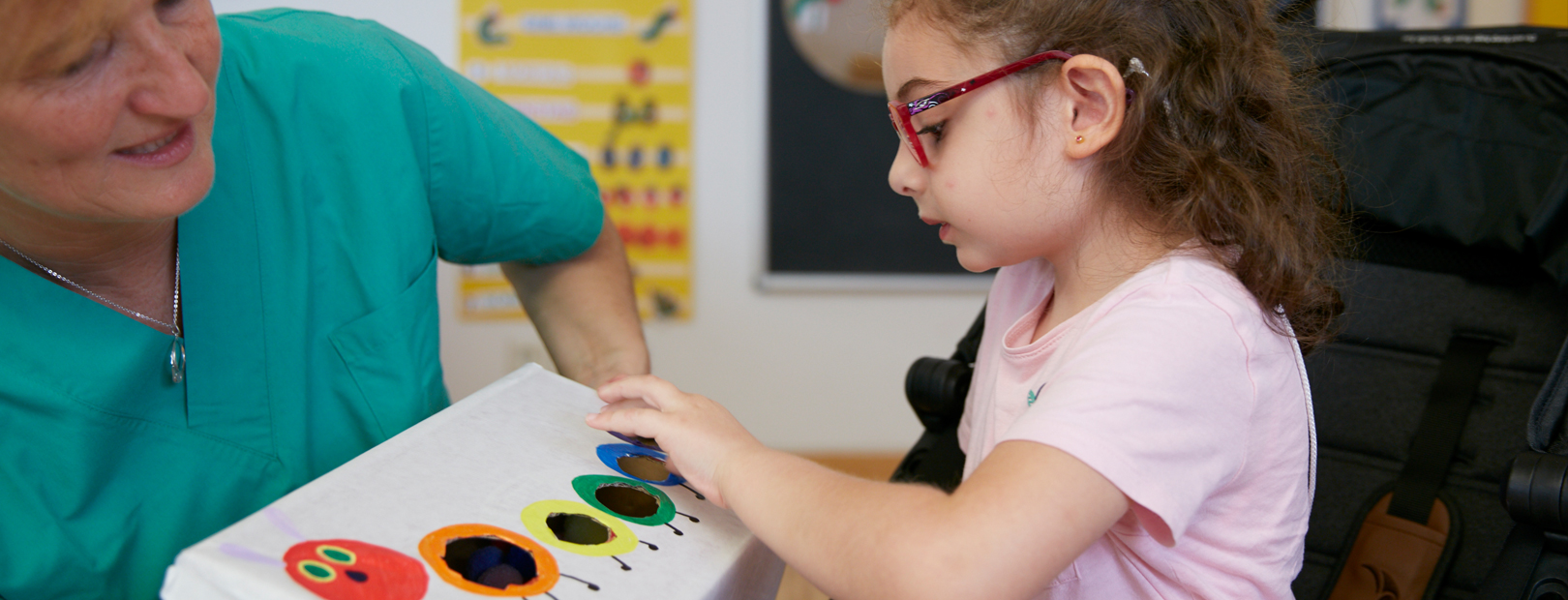 Picture: Educator exploring the image of a caterpillar together with a child.