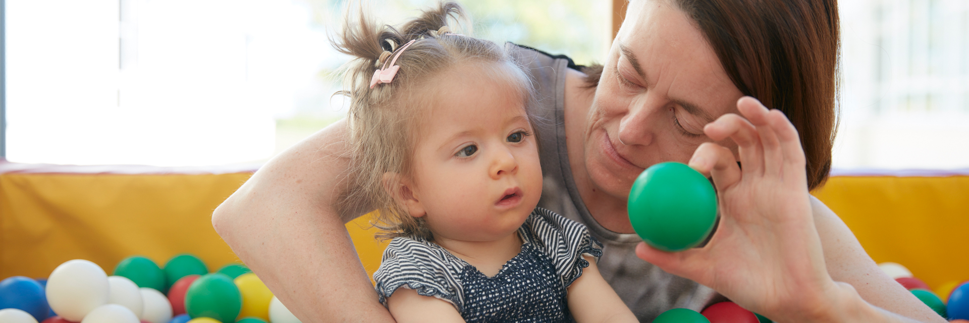 Bild: Eine Patientenmutter sitzt zusammen mit ihrer Tochter im Bällebad